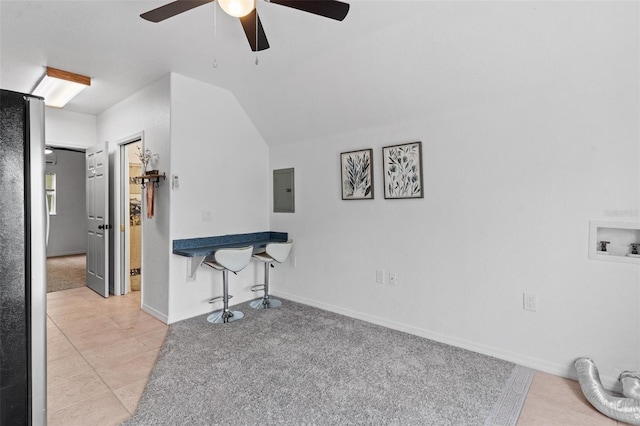 tiled living room with ceiling fan and vaulted ceiling