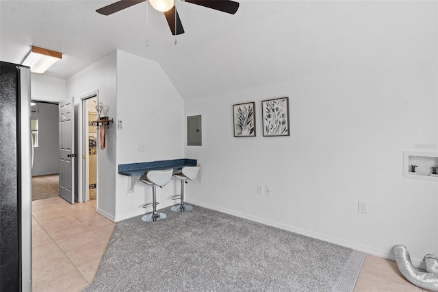 living room featuring vaulted ceiling, light colored carpet, electric panel, and ceiling fan