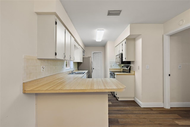 kitchen with white cabinets, sink, decorative backsplash, kitchen peninsula, and stainless steel appliances