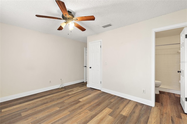 unfurnished bedroom with ensuite bath, ceiling fan, dark hardwood / wood-style floors, a textured ceiling, and a closet