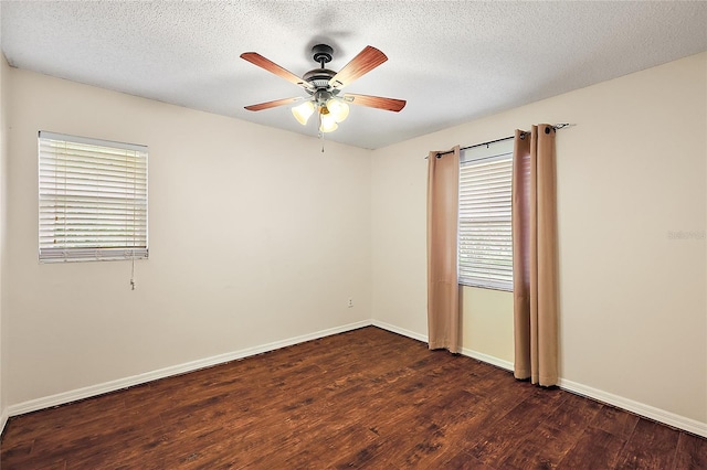 empty room with dark hardwood / wood-style floors, ceiling fan, and a textured ceiling