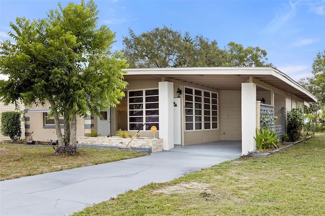 view of front facade featuring a front yard and a carport