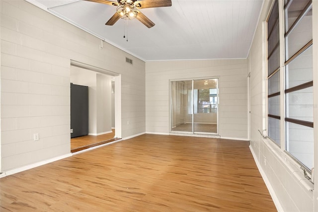 spare room with hardwood / wood-style floors, ceiling fan, crown molding, and vaulted ceiling