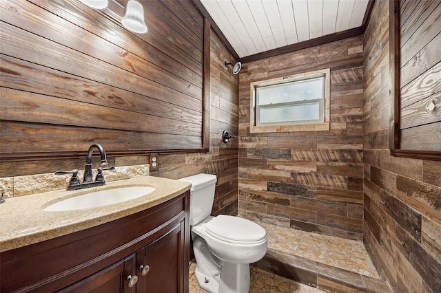 bathroom with vanity, wood walls, and toilet