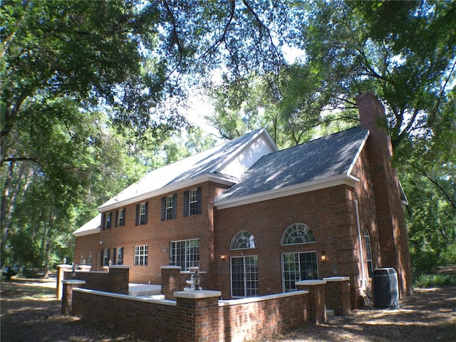 rear view of house featuring central AC unit and a patio