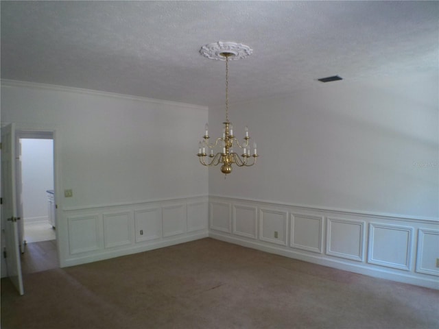 spare room with a notable chandelier, a textured ceiling, crown molding, and light colored carpet