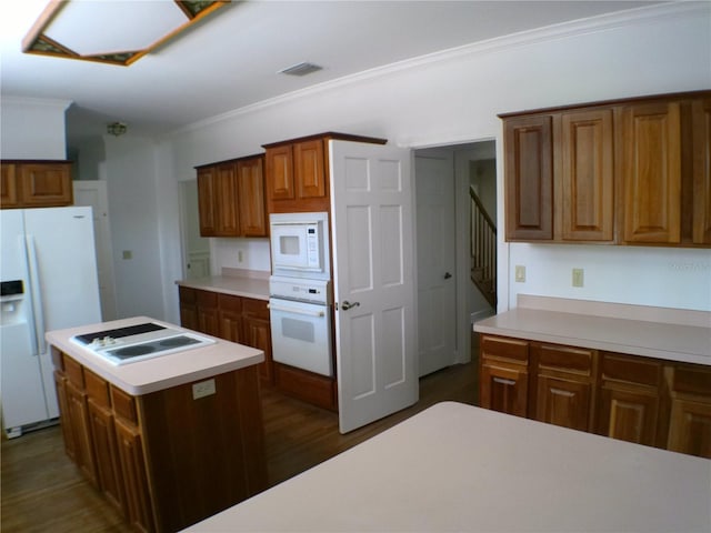 kitchen with a kitchen island, white appliances, crown molding, and dark wood-type flooring