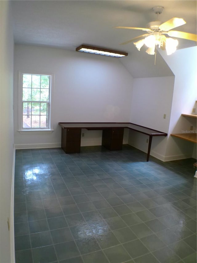 interior space with dark tile patterned flooring, ceiling fan, and built in desk