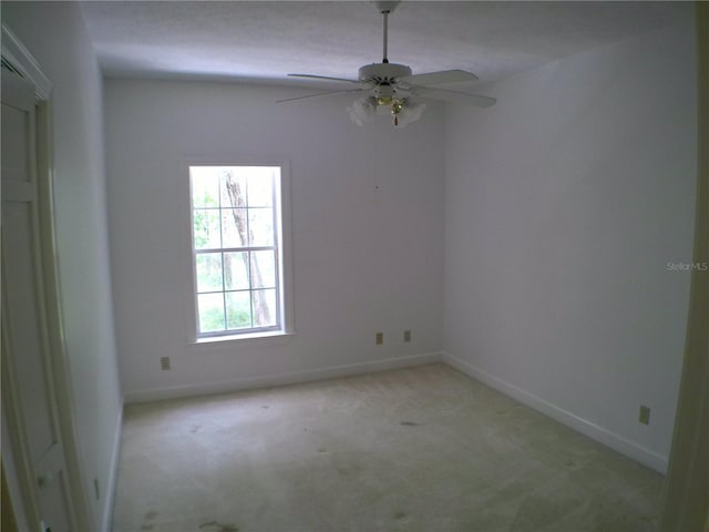 unfurnished room featuring light carpet and ceiling fan