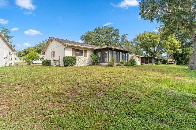 view of front of property with a sunroom and a front yard