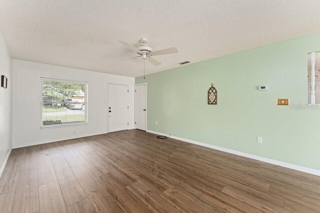 unfurnished room featuring ceiling fan, a textured ceiling, and dark hardwood / wood-style flooring