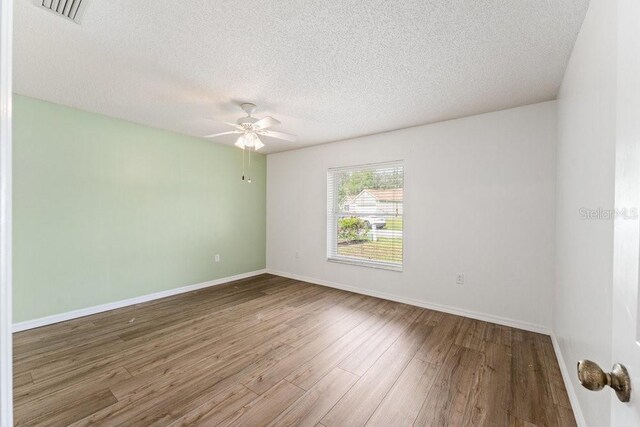 unfurnished room featuring hardwood / wood-style flooring, ceiling fan, and a textured ceiling