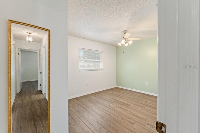 spare room featuring light hardwood / wood-style floors, a textured ceiling, and ceiling fan