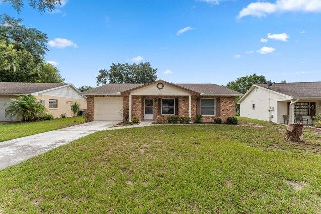 ranch-style house featuring a garage and a front lawn