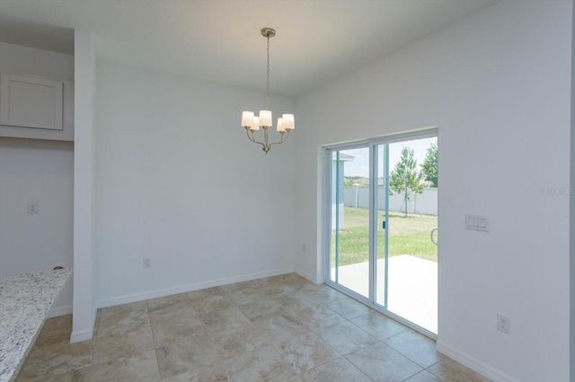 tiled spare room featuring a chandelier