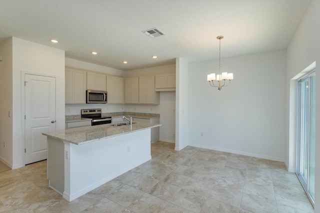 kitchen with sink, stainless steel appliances, light stone counters, a notable chandelier, and a kitchen island with sink