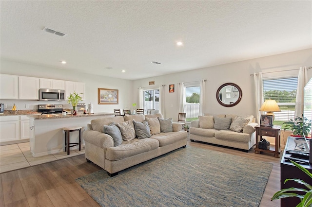 tiled living room featuring a textured ceiling