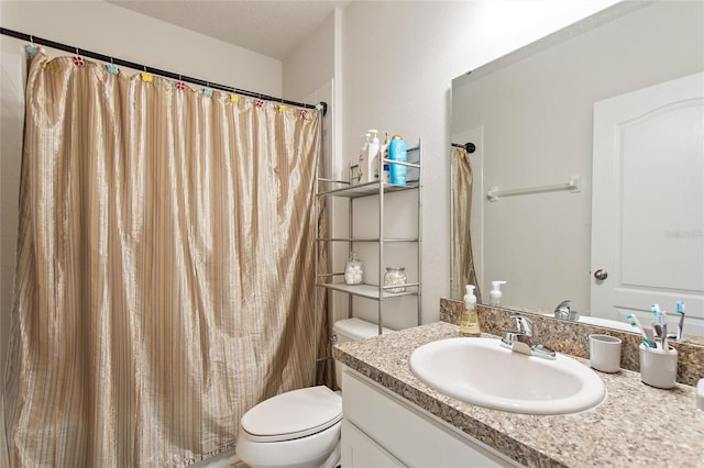 bathroom with a textured ceiling, toilet, and large vanity