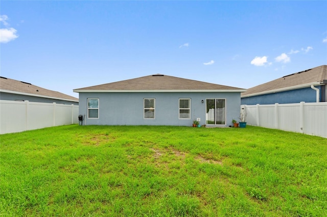 rear view of house featuring a yard