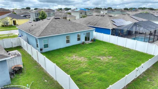 back of property featuring a lanai and a yard