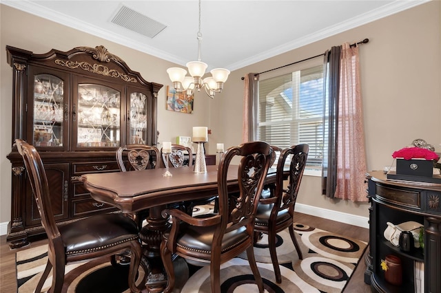 dining area with light hardwood / wood-style floors, crown molding, and a chandelier