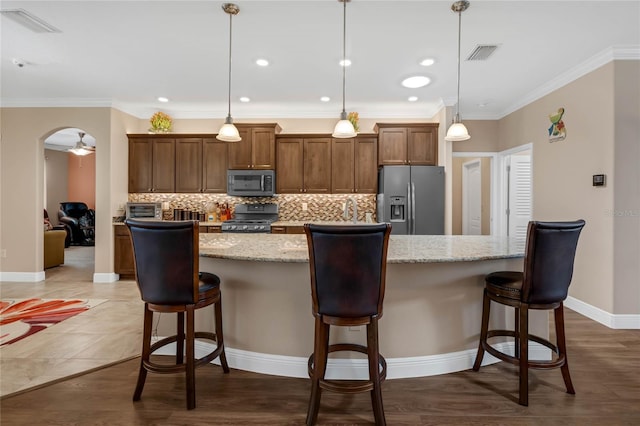 kitchen with decorative light fixtures, tasteful backsplash, hardwood / wood-style floors, and stainless steel appliances