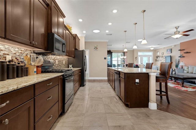 kitchen featuring light hardwood / wood-style flooring, stainless steel appliances, backsplash, hanging light fixtures, and ornamental molding