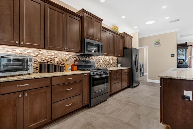 kitchen with appliances with stainless steel finishes, ornamental molding, tasteful backsplash, and separate washer and dryer