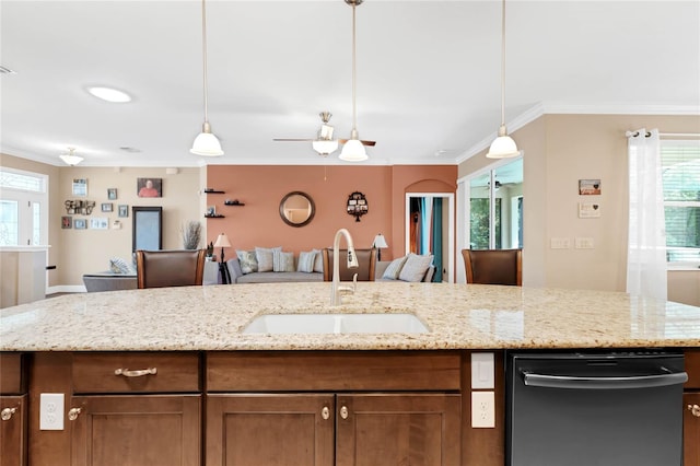 kitchen featuring sink, hanging light fixtures, light stone counters, and stainless steel dishwasher