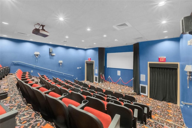 carpeted home theater room with a paneled ceiling