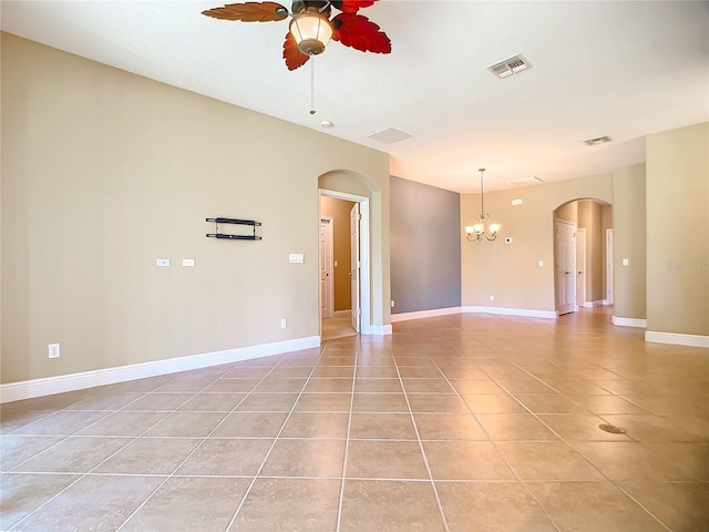 spare room with ceiling fan with notable chandelier and light tile patterned flooring