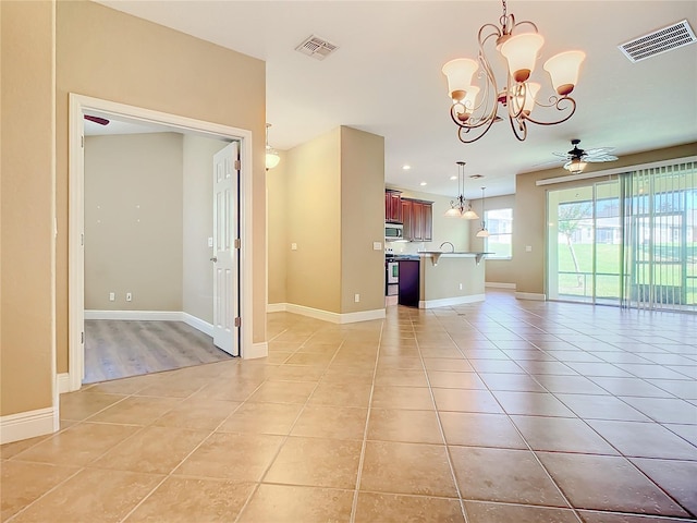 kitchen with electric range, ceiling fan with notable chandelier, light tile patterned flooring, and pendant lighting