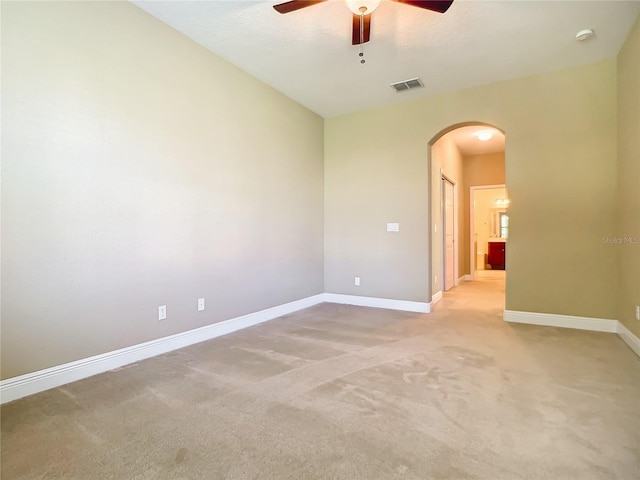 empty room featuring ceiling fan and light colored carpet