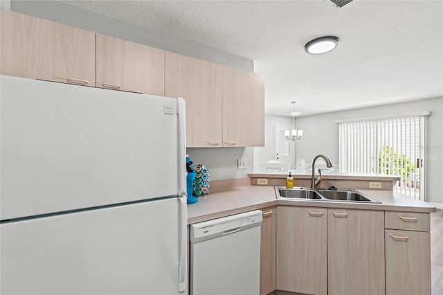 kitchen with kitchen peninsula, light brown cabinets, white appliances, and sink