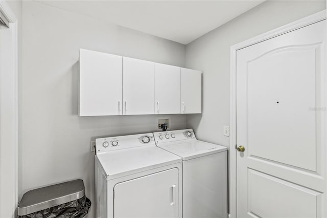 laundry area with washing machine and dryer and cabinets