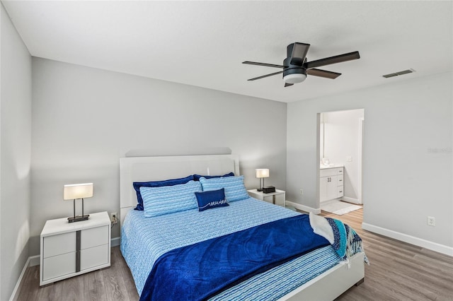 bedroom featuring ensuite bath, ceiling fan, and hardwood / wood-style flooring