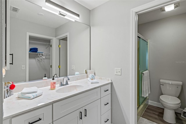 bathroom with toilet, vanity, hardwood / wood-style floors, and walk in shower