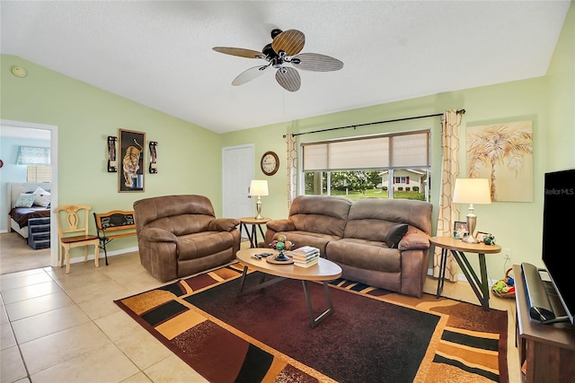 living room featuring lofted ceiling, ceiling fan, light tile patterned flooring, and a textured ceiling