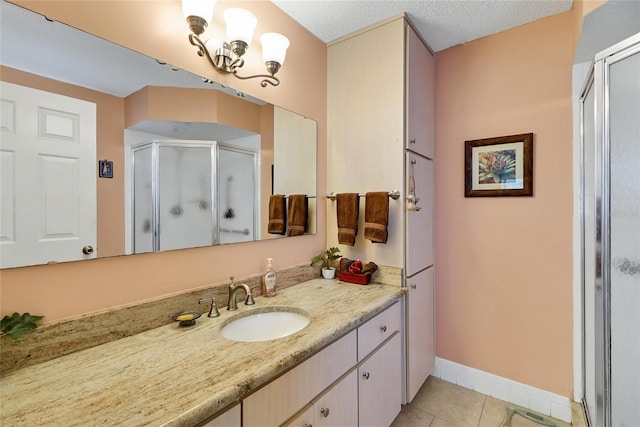 bathroom featuring tile patterned flooring, vanity, a shower with shower door, and a textured ceiling