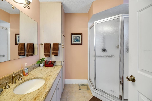 bathroom featuring tile patterned flooring, vanity, a textured ceiling, and an enclosed shower