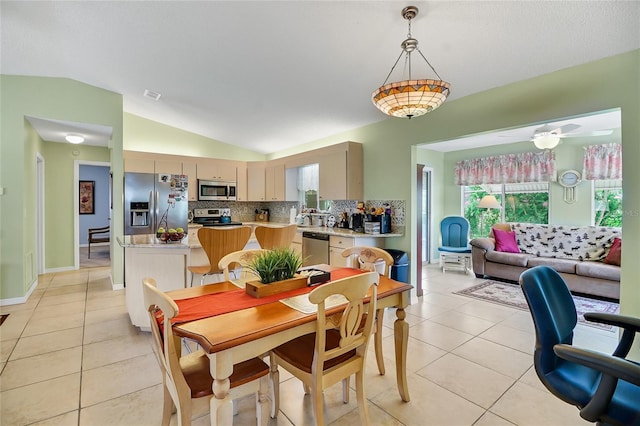 tiled dining room with vaulted ceiling and ceiling fan