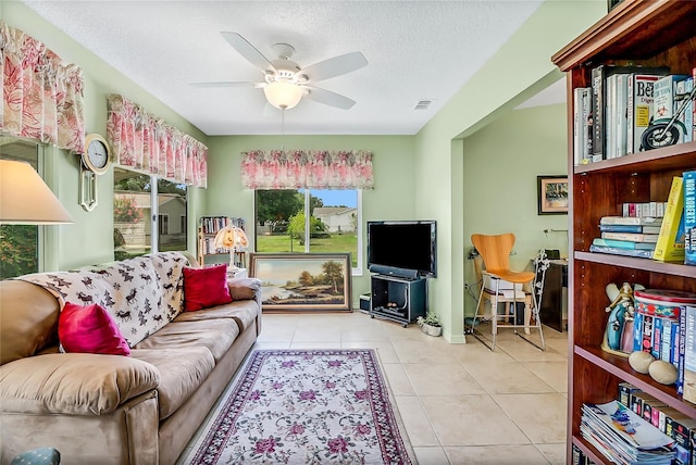 tiled living room with a textured ceiling and ceiling fan