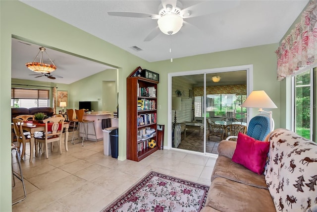 tiled living room with plenty of natural light and ceiling fan