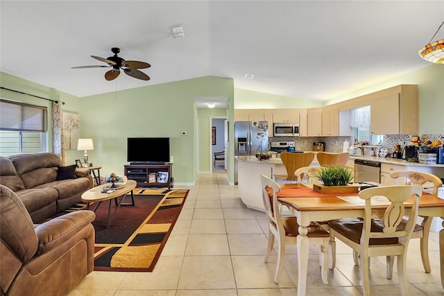 interior space with light tile patterned floors, vaulted ceiling, ceiling fan, and sink