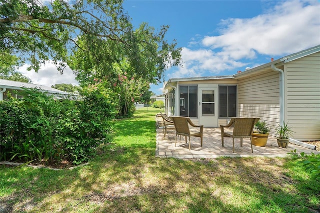 view of yard featuring a sunroom and a patio