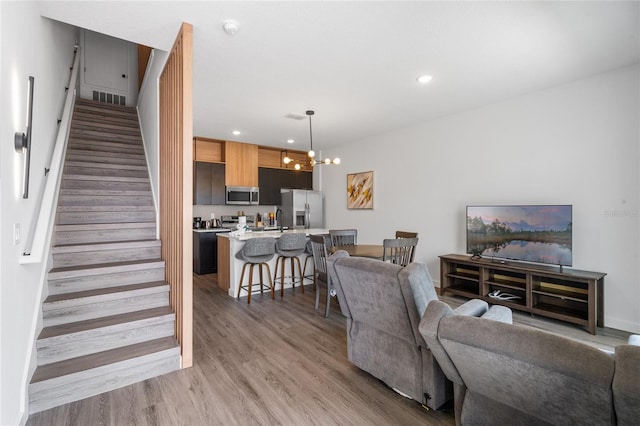 living room with hardwood / wood-style flooring, a chandelier, and sink