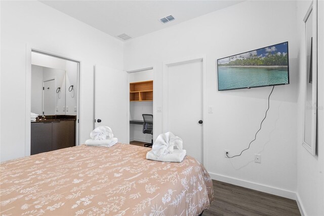 bedroom featuring built in desk and dark hardwood / wood-style floors