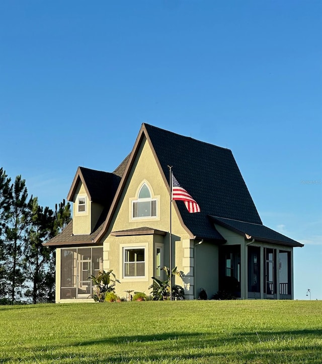 view of front of home featuring a front yard and a sunroom