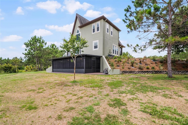 back of property with a sunroom and a lawn