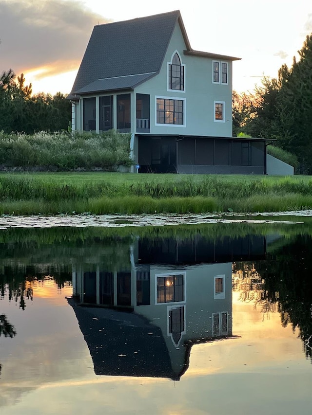 exterior space with a water view and a sunroom